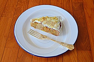 Side View Angle of Carrot cake served on classic enamelware with silver spoon