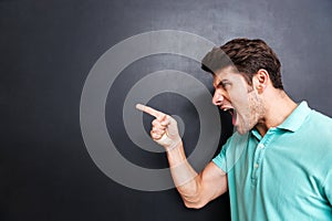 Side view of a angry man screaming over black background