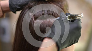 Side view applying regrowth moisturizer on hair skin rubbing liquid with hand in gloves. Close-up of Caucasian young