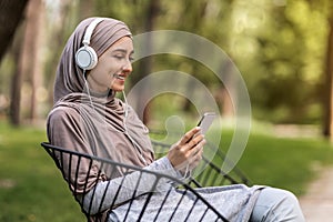 Side view of arab girl listening to music at park