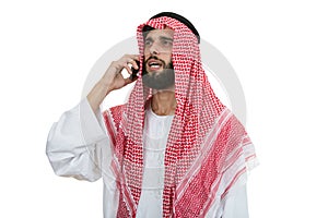 Side view of an arab saudi emirates man using a smart phone.