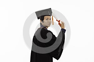 Side view of Asian Graduate man in cap and gown smile with certificated or diploma so proud