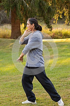 Side view of an Asian man practicing Tai Chi