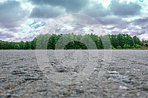 Side view of asphalt country road with dark cloudy sky background