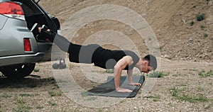 Side View of Athletic Man in Black Sportswear Doing Pushups Open Air by Car, Healthy Lifestyle and Outdoors Workout