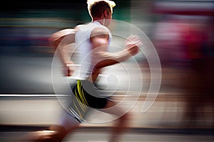 Side view of athletic runner with motion blur on city street