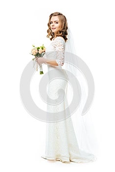 Side view of attractive bride in wedding dress and veil with bouquet of flowers