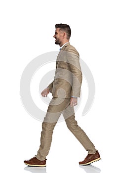 Side view of attractive man in his 40s smiling and walking