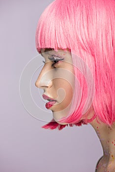 side view of attractive woman with pink hair and glitter on face