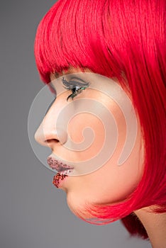 side view of attractive woman with red hair and glitter on face