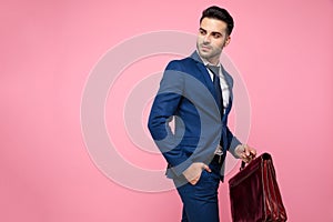 Side view of attractive young man holding suitcase