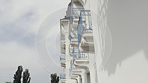 Side view of balconies with blue wrought iron railing of modern building, architectural background. Action. White wall