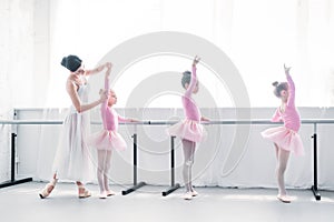 side view of ballet teacher exercising with children