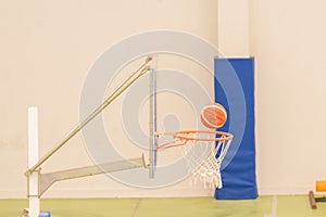 side view of basketball entering a mini-basketball basket