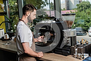 side view of bearded barista frothing