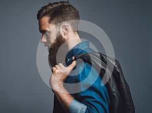 Side view on bearded man holding black jacket