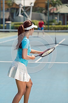 Beautiful and competitive woman smiling before starting a tennis match