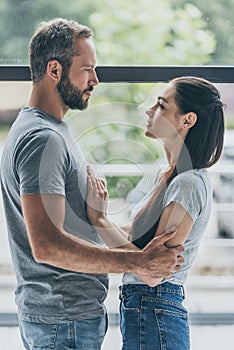 side view of beautiful couple looking at each other while standing together photo
