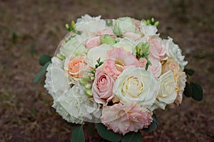 Side view of a beautiful delicate wedding bouquet of cream roses and eustoma blurred background.