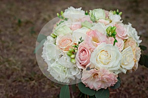 Side view of a beautiful delicate wedding bouquet of cream roses and eustoma blurred background.