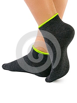 Side view of beautiful woman foot dressed in new nice and soft natural cotton fabric blank black socks with light green edging