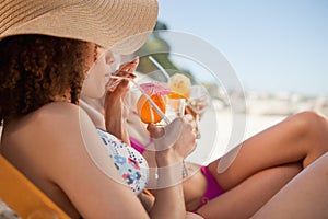 Side view of a beautiful woman sipping her cocktail accompanied