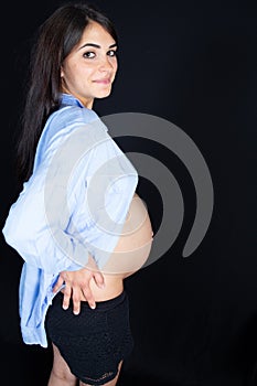 Side view of beauty pretty pregnant woman profile in black background