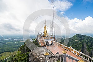 Side view of Big Golden Buddha statue against cloudy sky in Tiger Cave temple