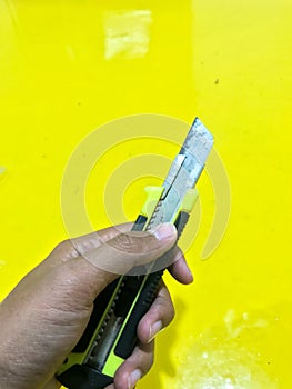 Side view of black yellow utility knife