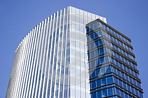 Side view of a blue modern corporate high-rise building with a striped design.