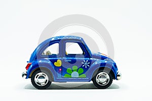 Side view of blue vintage car toy with colorful flowers paint