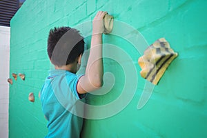 Side view of boy climbing wall