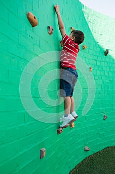 Side view of boy climbing wall at playground