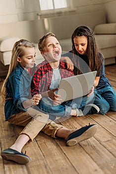 Side view of boy and girls using digital laptop