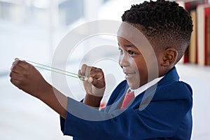 Side view of boy playing with rubber band