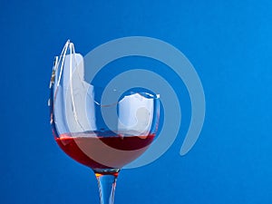 Side view of a broken glass with red wine
