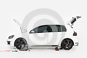 side view of broken white car with open trunk and open hood photo