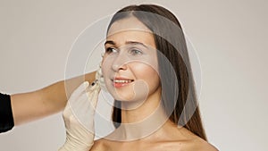 Side view of brunette caucasian woman has the beauty injections in her face slow motion