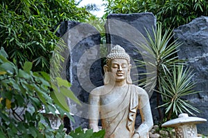 Side view of the Buddha statue with beautiful rocks in the background. Inner peace concept
