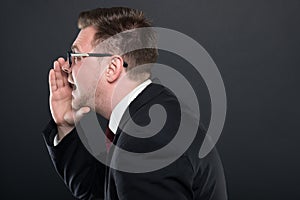 Side view of business man screaming out loud