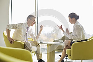 Side view of business people conversing at lobby