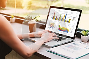 Side view of business woman using the laptop work to making sale