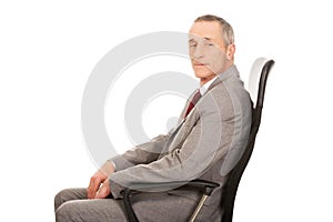 Side view of businessman sitting on armchair