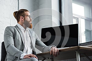 side view of businessman sitting at table with computer