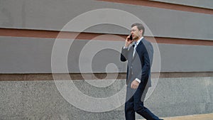 Side view businessman talking phone at street. Man talking phone with partner