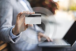 Side view businesswoman holding credit card while using laptop . High quality and resolution beautiful photo concept