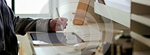 Side view of businesswoman working on blank screen tablet on white office desk