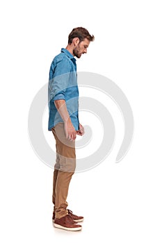 Side view of a casual man looking down at something