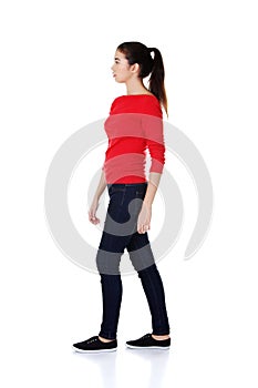Side view of a casual young woman walking