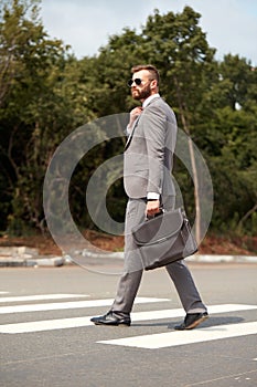 Side view on caucasian businessman walking with bag